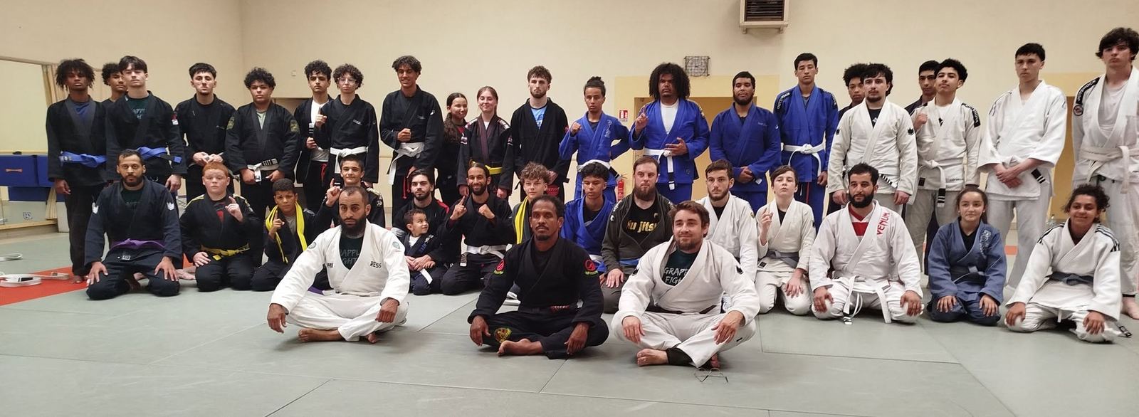 Photo de groupe des adhérents du Cholet Fight Club, enfants, ados et adultes en kimono, sur le tapis du Dojo du Plessis